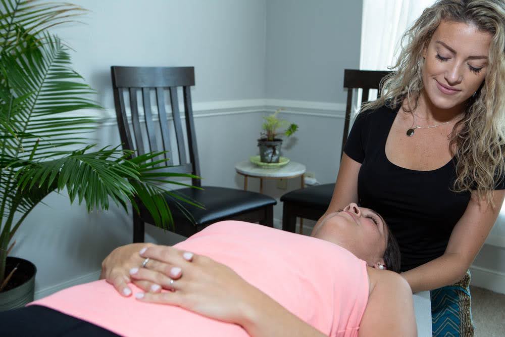 Dr. Samantha Bahan adjusting the neck and shoulders of a patient | Chiropractor in Lakewood Ohio